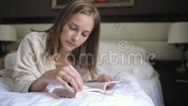 女人在翻书页，躺在床上看书